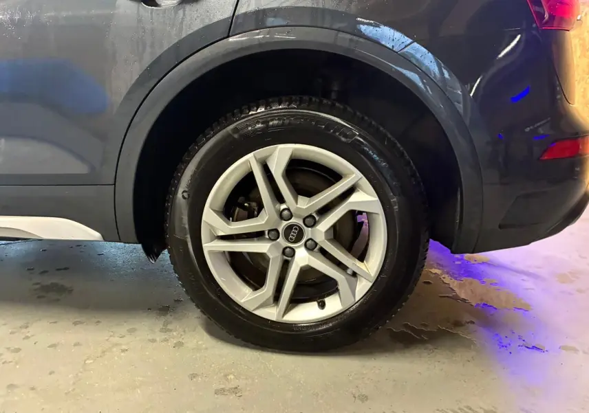 Gros plan sur la roue arrière droite grise d’un Audi Q5 2024 avec jante aluminium à 5 branches doubles.