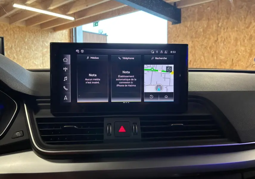 Écran central tactile du tableau de bord de l'Audi Q5 2024 avec navigation et commandes multimédia.