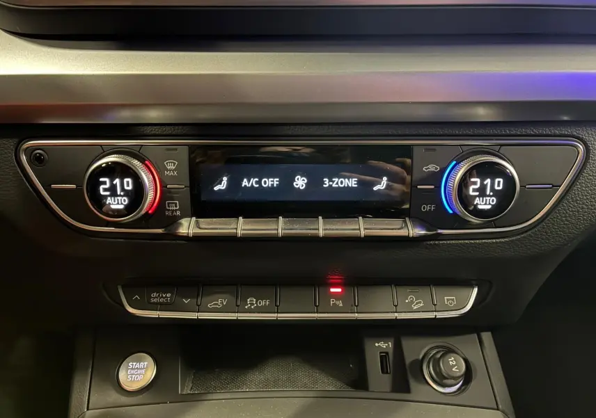 Détail du tableau de bord de l'Audi Q5 hybride 2024 montrant la climatisation automatique 3 zones à 21°C.