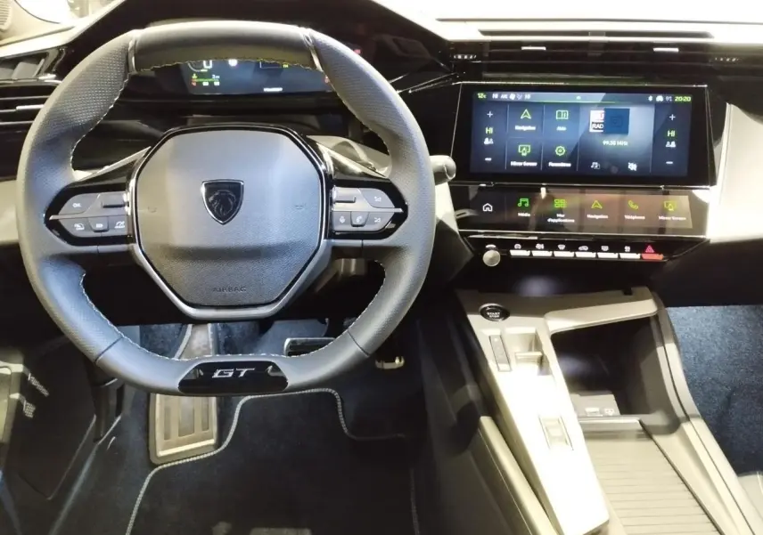 Vue intérieure centrée sur le volant GT noir et le tableau de bord numérique avec écran tactile de la Peugeot 308 gris Artense.