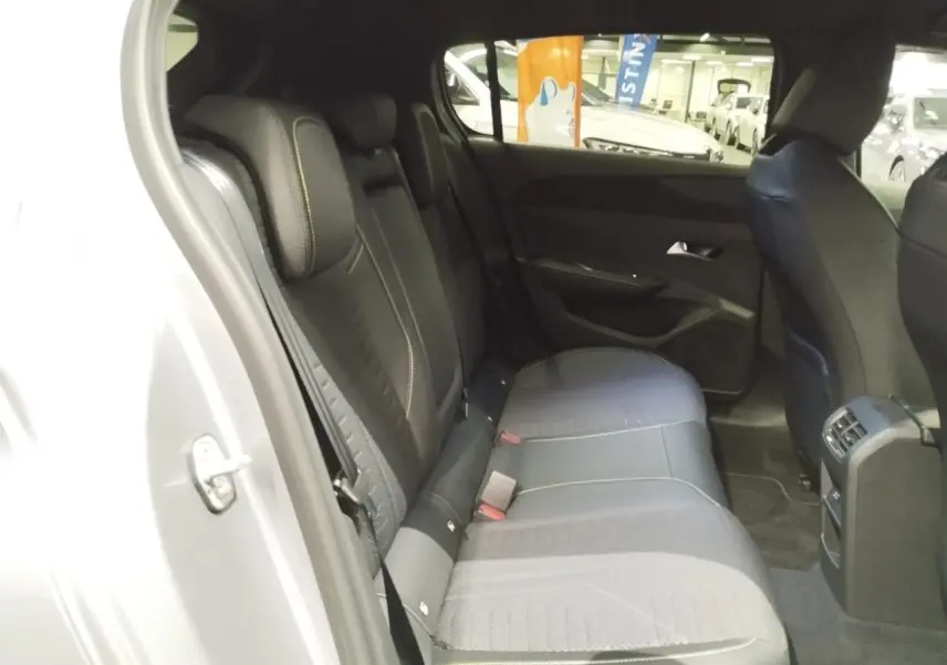Vue intérieure de la banquette arrière noire avec surpiqûres vert Adamite dans une Peugeot 308 gris Artense.
