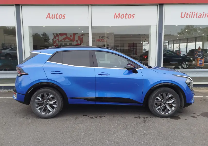 Profil droit du KIA SPORTAGE bleu métallisé, soulignant ses lignes modernes et ses jantes alliage distinctives.