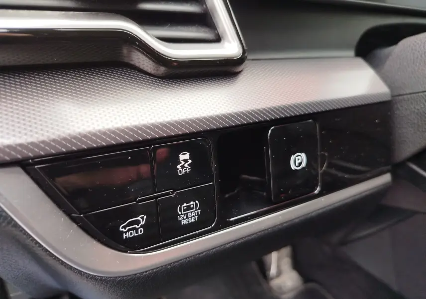 Gros plan sur les commandes noires du tableau de bord du Kia Sportage 2022, avec finition texturée grise.
