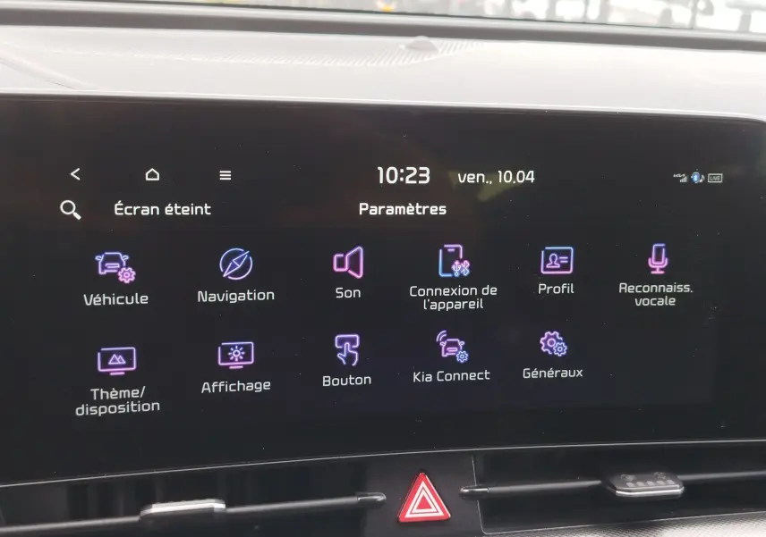 Écran tactile central du Kia Sportage 2022 affichant le menu des paramètres avec icônes colorées sur fond noir.