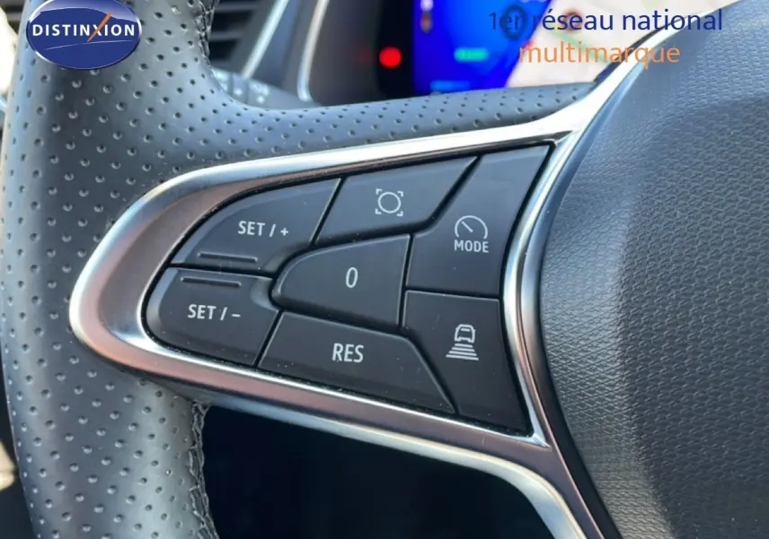 Gros plan sur les commandes de régulateur de vitesse au volant perforé d’une Renault Symbioz noire étoile métal, intérieur moderne.