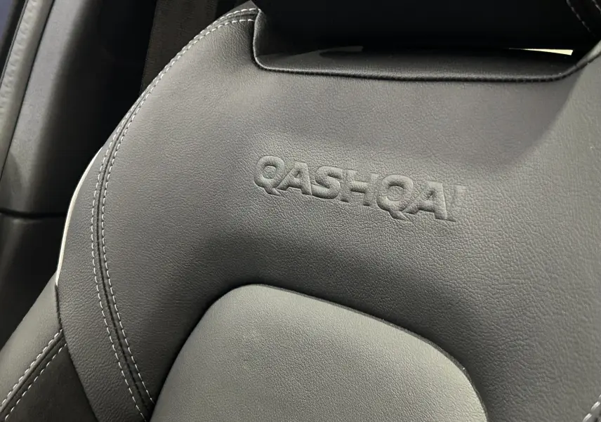 Gros plan sur l'appui-tête en cuir noir embossé du logo QASHQAI à l'intérieur du Nissan Qashqai 2025.