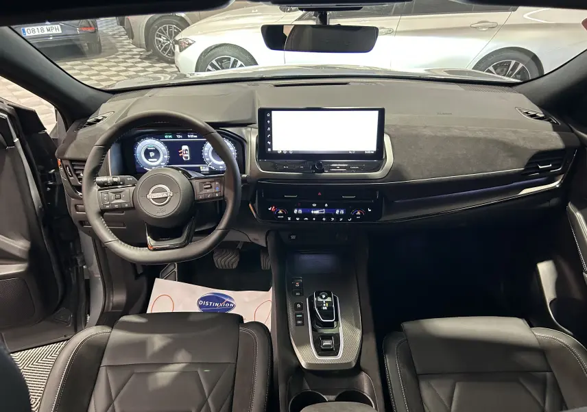 Intérieur du Nissan Qashqai 2025 vu de face, tableau de bord moderne avec écran tactile large et volant multifonction noir.