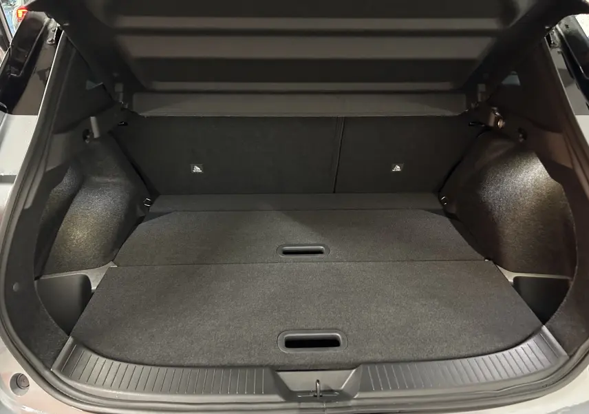 Coffre ouvert du Nissan Qashqai 2025 gris céramique, vue intérieure arrière montrant l'espace de chargement plat.