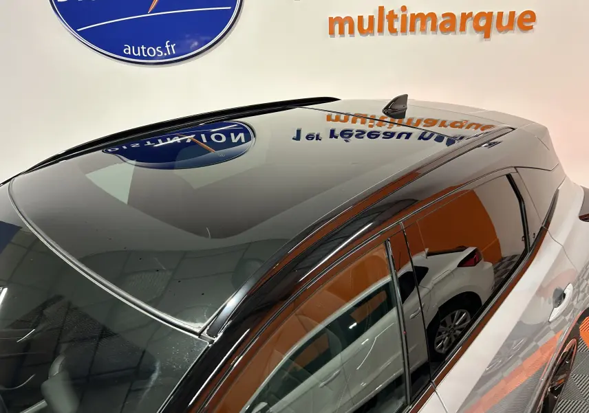 Vue plongeante sur le toit panoramique noir et la carrosserie gris céramique métallisé du Nissan Qashqai 2025 côté gauche.