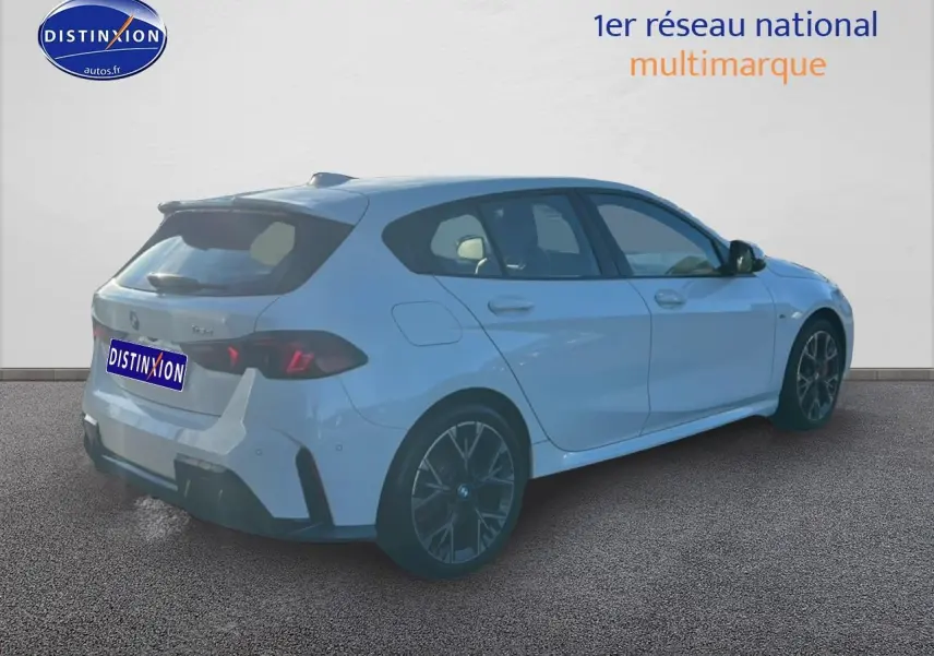 BMW Série 1 blanche alpin vue 3/4 arrière droit, avec jantes 18 pouces bicolores et pack M Sport Pro.