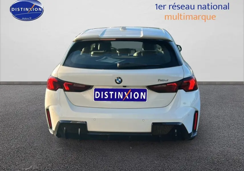 Vue arrière d'une BMW Série 1 118da blanche alpin avec feux LED et diffuseur noir, version M Sport Pro 2025.