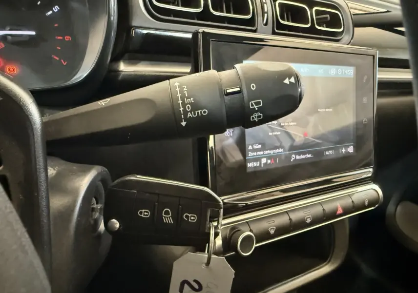Gros plan sur le tableau de bord noir de la Citroën C3 2021, avec écran tactile et commande d’essuie-glace.
