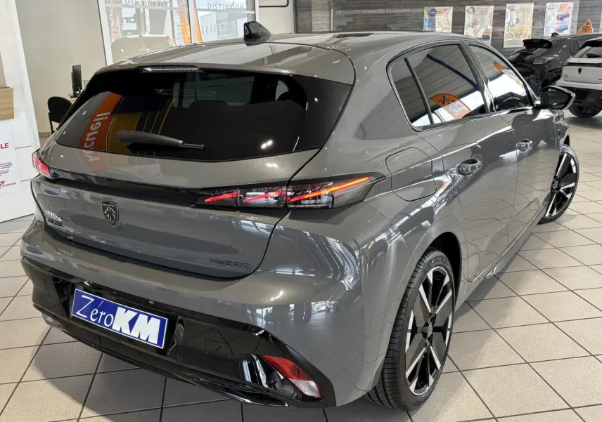 Vue 3/4 arrière droite d’une Peugeot 308 hybride gris selenium avec feux arrière LED et jantes alliage bi-tons.