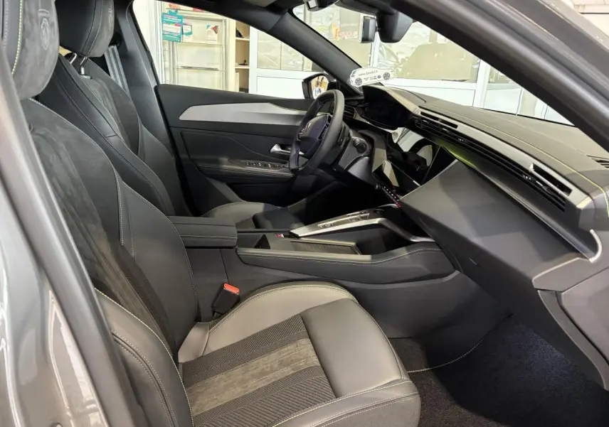 Vue intérieure côté conducteur de la Peugeot 308 gris selenium, avec sièges Alcantara noirs et surpiqûres vert Adamite.