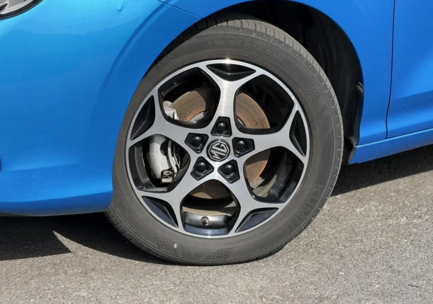 Gros plan sur la roue avant droite avec jante alliage 16'' et carrosserie bleu Como d'une MG3 1.5 Hybrid+ 2024.