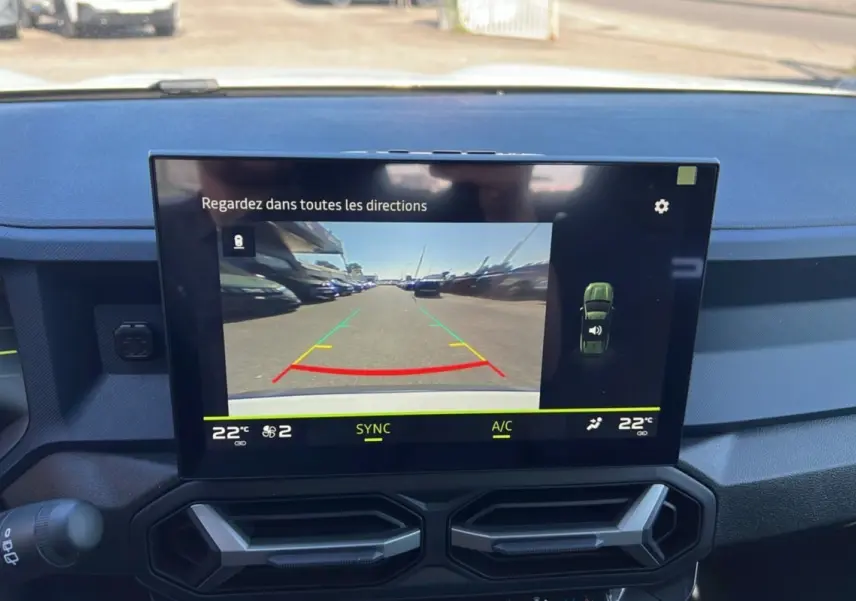 Écran central du tableau de bord du Dacia Bigster 2025 montrant la caméra de recul et la climatisation à 22°C.