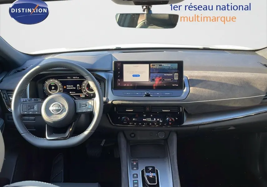 Intérieur du Nissan Qashqai 2025 avec tableau de bord moderne, écran tactile central et volant multifonction noir.