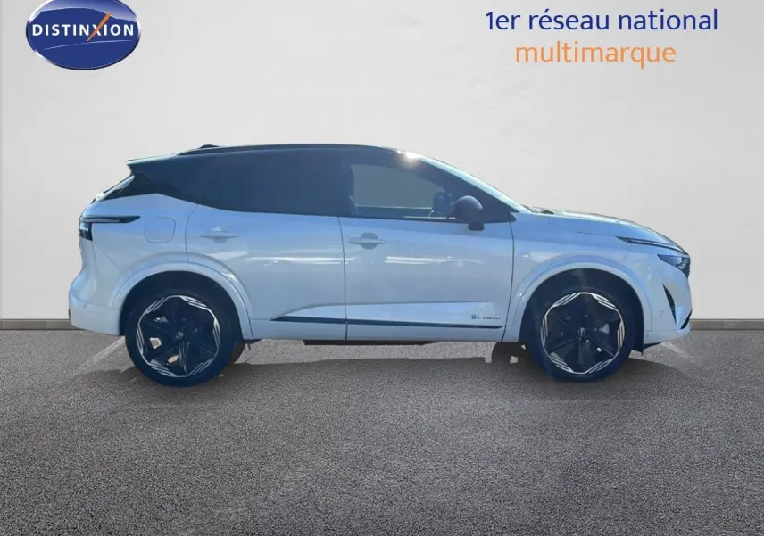 Profil latéral gauche du Nissan Qashqai blanc nacré avec toit noir, roues noires et lignes modernes visibles.