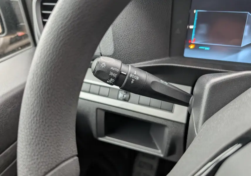 Gros plan sur la manette de commande d'éclairage à gauche du volant du Citroën Jumpy gris 2025.