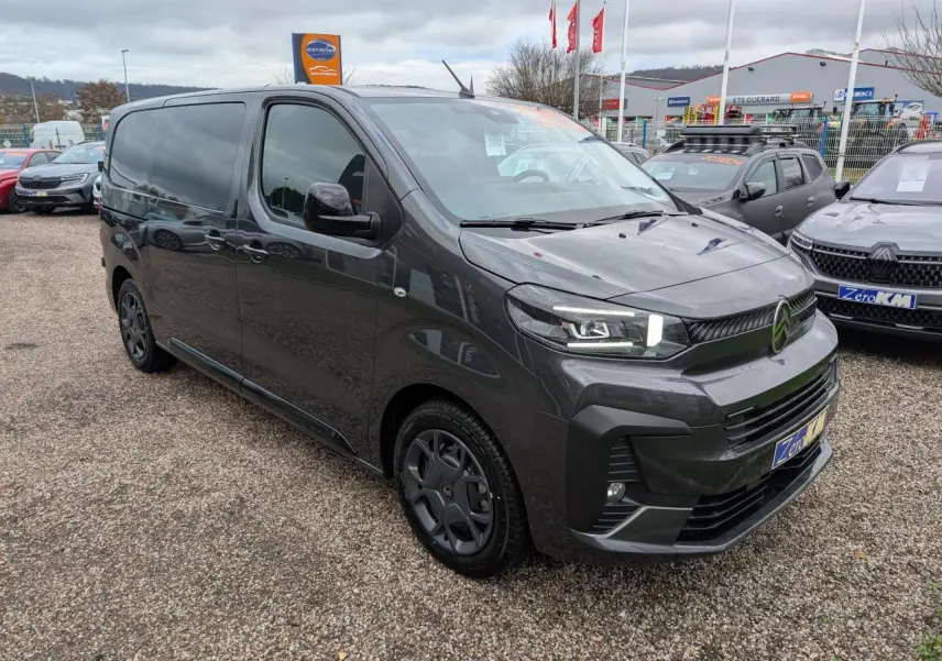 Vue 3/4 avant droit d'un Citroën Jumpy gris avec boucliers couleur carrosserie et coques de rétroviseurs noires Perla Nera.