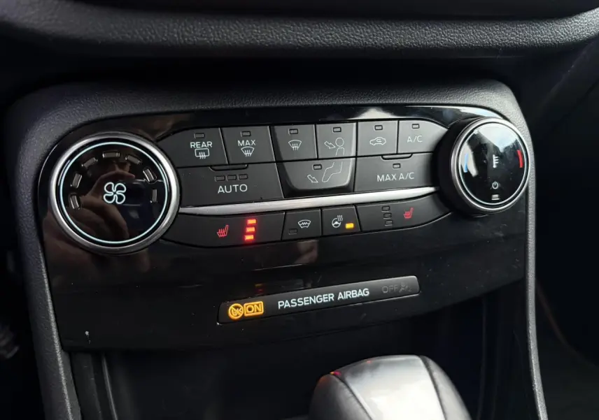 Vue rapprochée du tableau de bord de la Ford Puma 2023, montrant les commandes de climatisation et sièges chauffants activés.