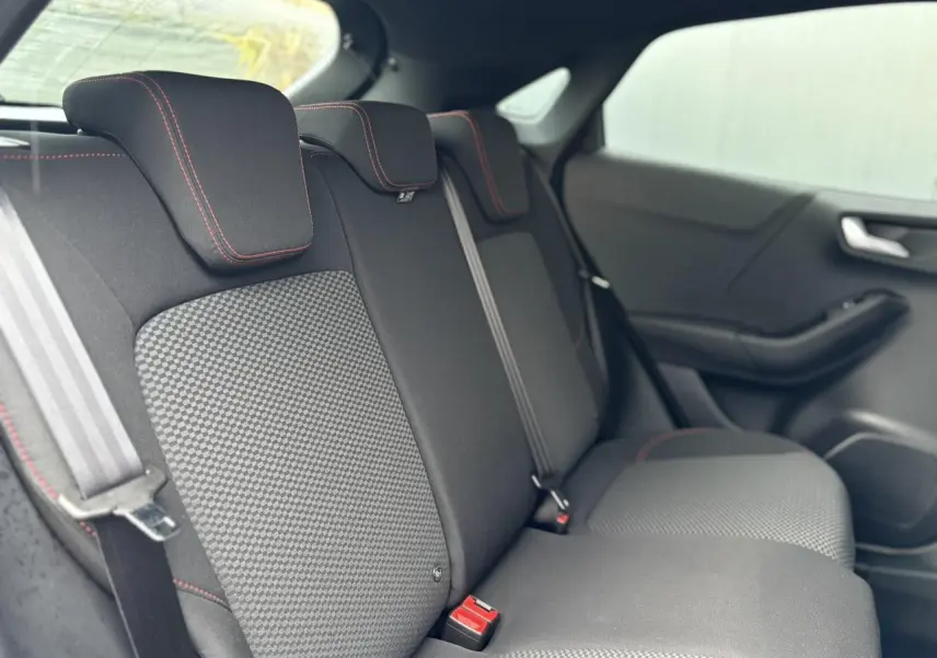 Vue intérieure côté droit des sièges arrière du Ford Puma 2023 avec surpiqûres rouges et tissu bicolore.
