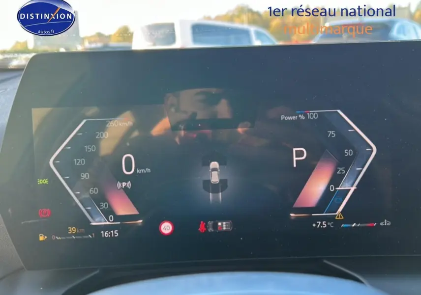 Tableau de bord numérique de BMW Série 1 blanc alpin, affichage digital moderne avec vitesse et mode stationnement visible.