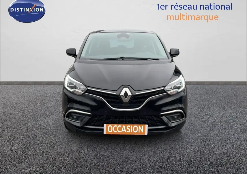 Vue avant d'un Renault Grand Scénic noir étoile métal avec calandre chromée et phares LED allumés.