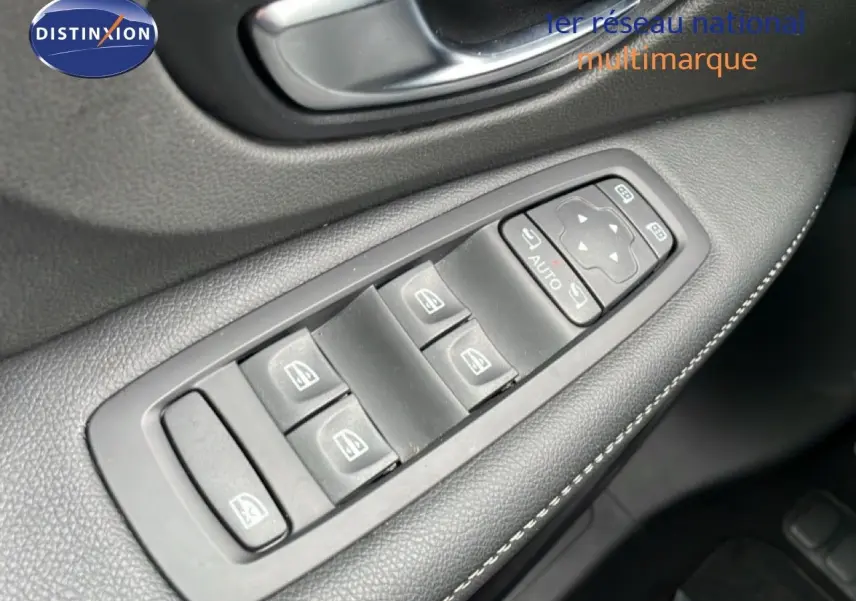 Gros plan sur les commandes de lève-vitres côté conducteur d’un Renault Grand Scénic noir étoile métal, intérieur cuir noir.