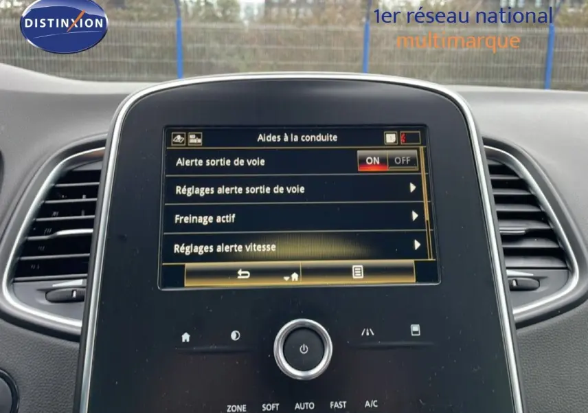 Vue intérieure centrée sur l’écran tactile du Renault Grand Scenic noir étoile métal, affichant les aides à la conduite.