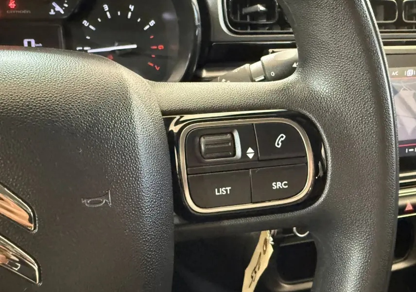 Gros plan sur le volant multifonctions noir de la Citroën C3 2021, avec commandes audio et téléphone visibles.