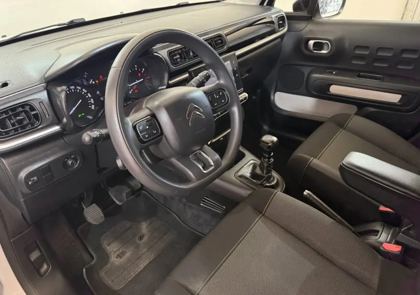 Intérieur avant droit de la Citroën C3 blanche 2021, volant multifonctions, boîte manuelle et tableau de bord moderne.