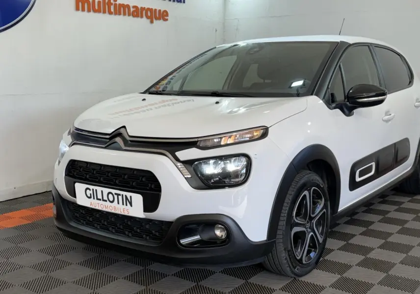 Vue 3/4 avant droite d'une Citroën C3 blanche avec phares LED et protections latérales noires.