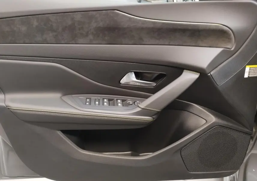 Détail de la porte avant gauche de la Peugeot 308 gris selenium, avec commandes de vitres et surpiqûres vert Adamite.