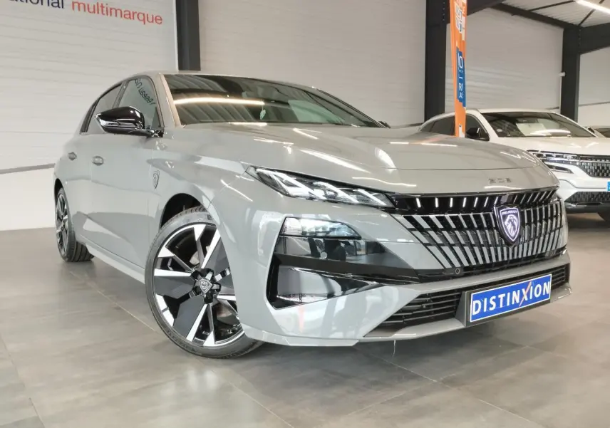 Peugeot 308 gris selenium vue 3/4 avant avec calandre noire et jantes alliage bi-ton distinctives.