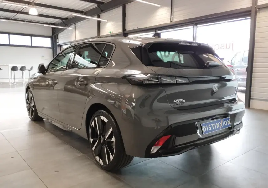 Vue 3/4 arrière droite d'une Peugeot 308 gris selenium avec jantes alliage bi-tons et feux arrière LED griffés.