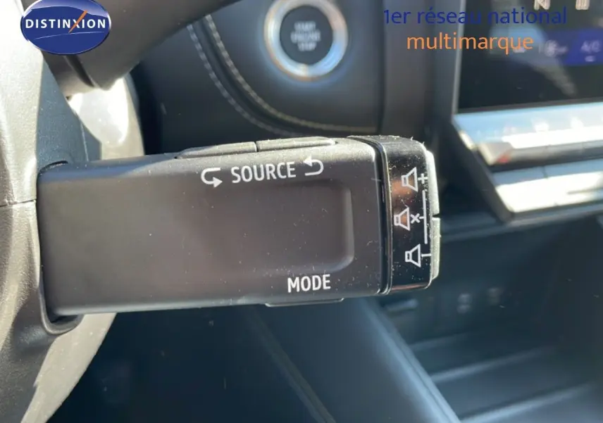 Gros plan sur la commande au volant noire avec boutons source et mode dans l'habitacle d'une Renault Symbioz noire étoile métal.