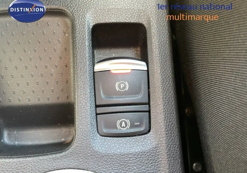 Gros plan sur les commandes de frein à main électronique et auto hold dans l'habitacle d'une Renault Symbioz noire.
