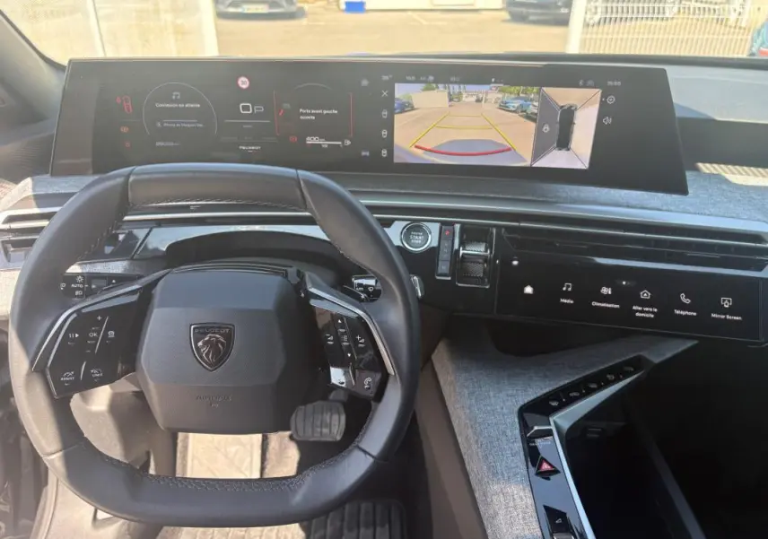 Vue intérieure du poste de conduite du Peugeot 3008 Hybrid 145 e-DCS6 Allure 2025, avec volant compact et écran numérique panoramique.