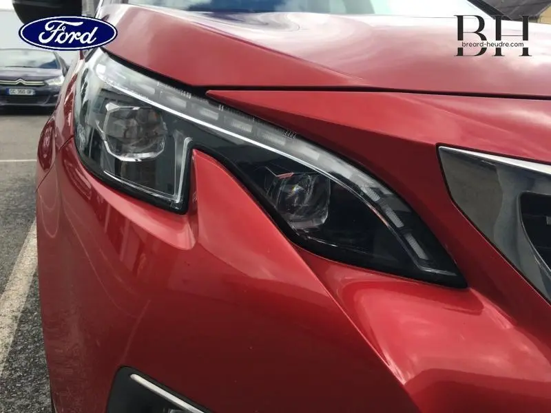 Gros plan sur le phare avant gauche rouge Ultimate d'un Peugeot 3008 avec signature lumineuse LED distinctive.
