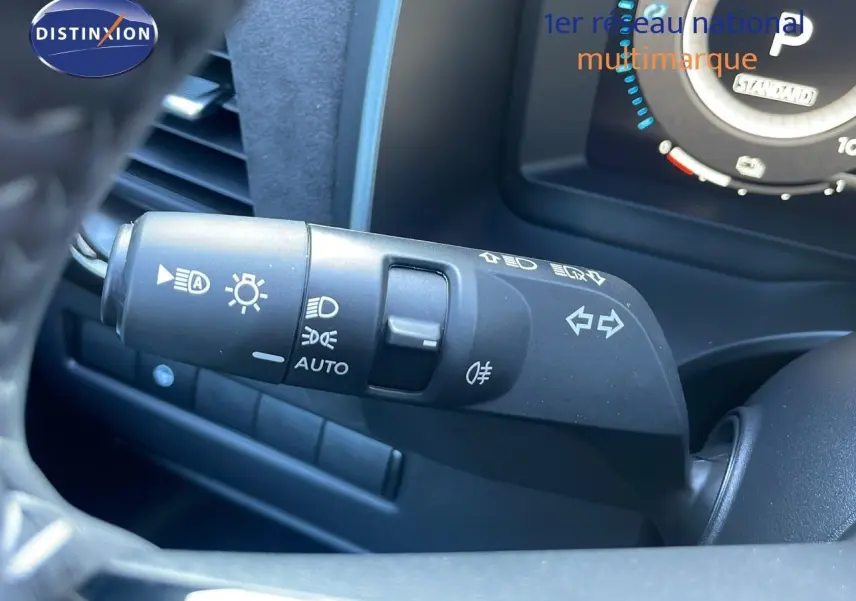 Gros plan sur la commande des phares et clignotants du Nissan Qashqai 2025, intérieur noir moderne.