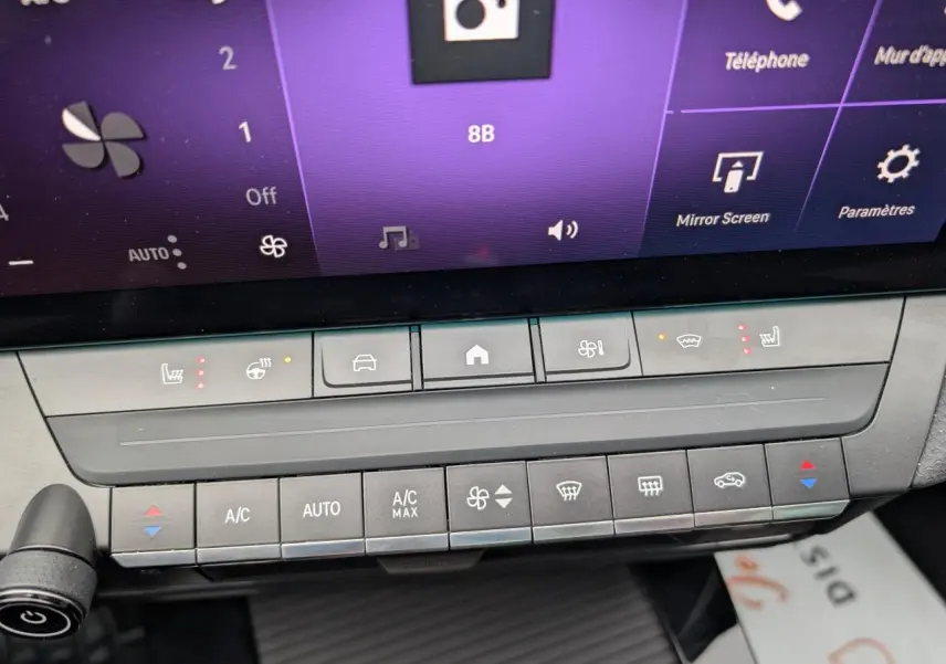 Gros plan sur la console centrale tactile de l'Opel Astra 2024, montrant les commandes de climatisation et sièges chauffants.