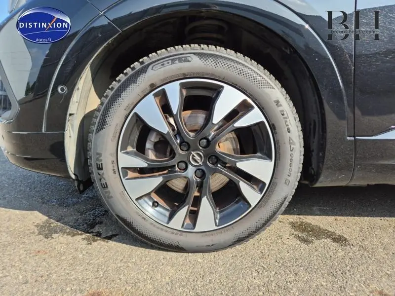 Gros plan sur la roue avant droite avec jante alu bicolore du SUV Opel Grandland noir diamant métallisé 2022