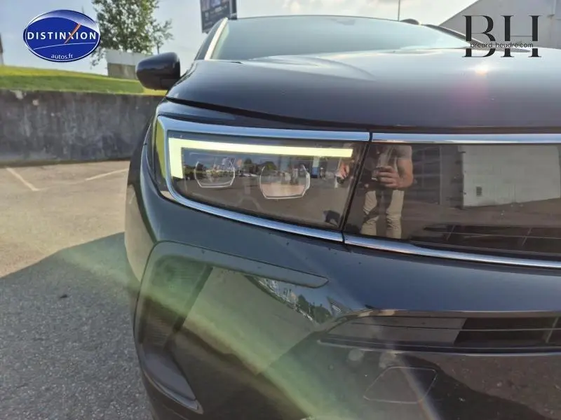 Gros plan sur le phare avant gauche du SUV Opel Grandland noir Diamant métallisé avec signature lumineuse LED distinctive.