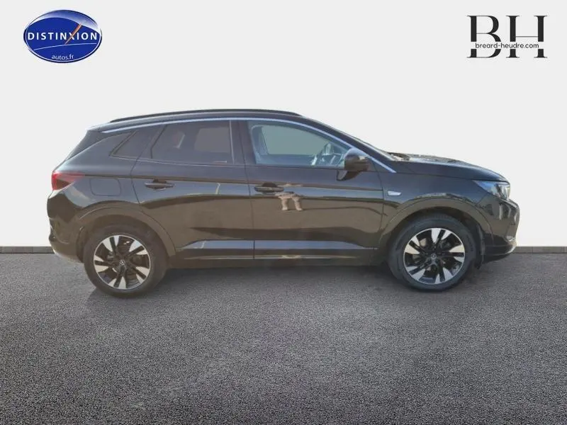 Profil droit d'un Opel Grandland 1.2 Turbo 130ch Ultimate 2022 en noir diamant métallisé avec jantes alu bicolores.