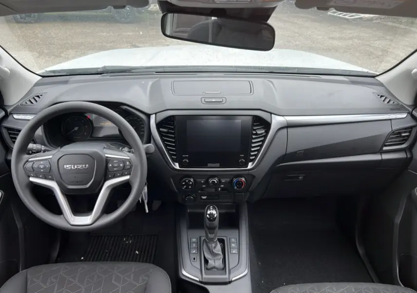 Vue intérieure frontale du tableau de bord noir et volant multifonctions de l'Isuzu D-MAX Splash White 2026.