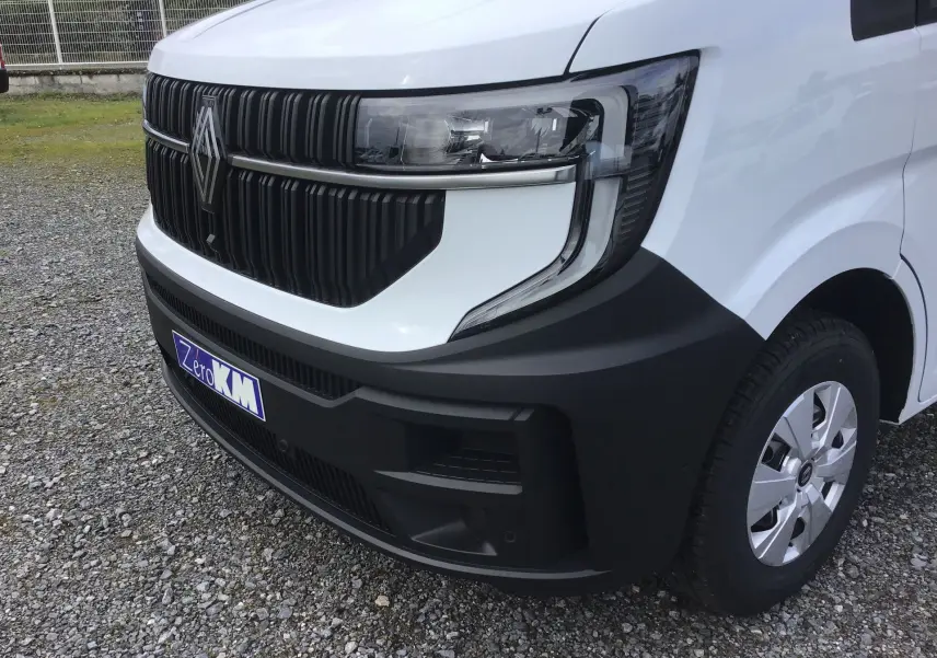 Gros plan sur l’avant droit du Renault Master blanc 2025 avec calandre noire et phares modernes.