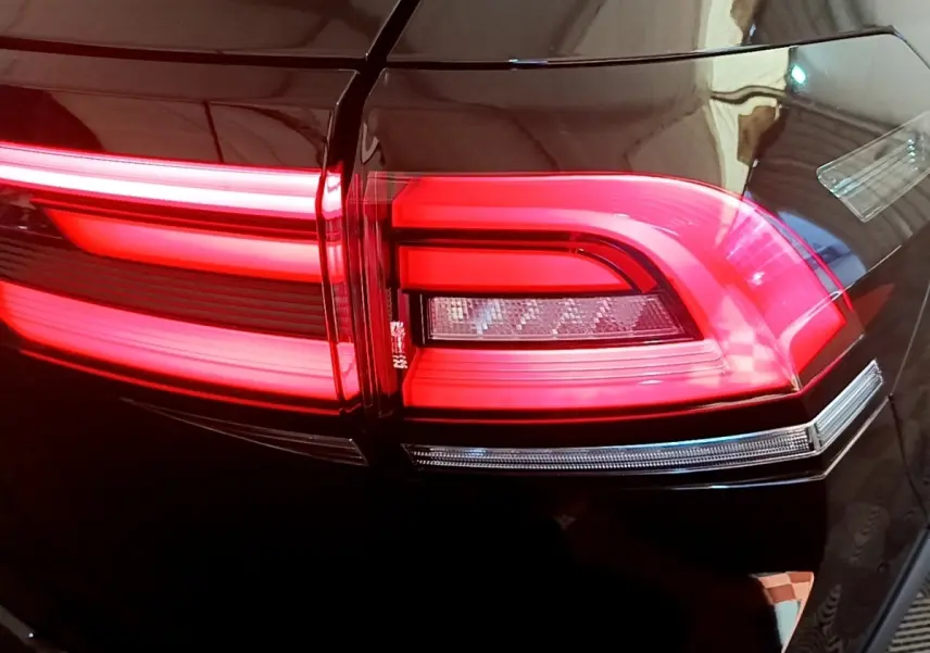 Gros plan sur le feu arrière droit rouge allumé du Volkswagen Taigo noir 2023, soulignant ses lignes LED distinctives.