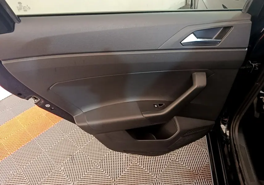 Vue intérieure du panneau de porte côté gauche noir du Volkswagen Taigo 1.5 TSI 150 DSG R-Line 2023 avec poignée intégrée.