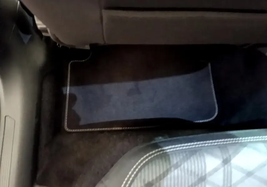 Détail du tapis de sol noir sous le siège arrière d'un Volkswagen Taigo 1.5 TSI 150 DSG R-Line 2023.
